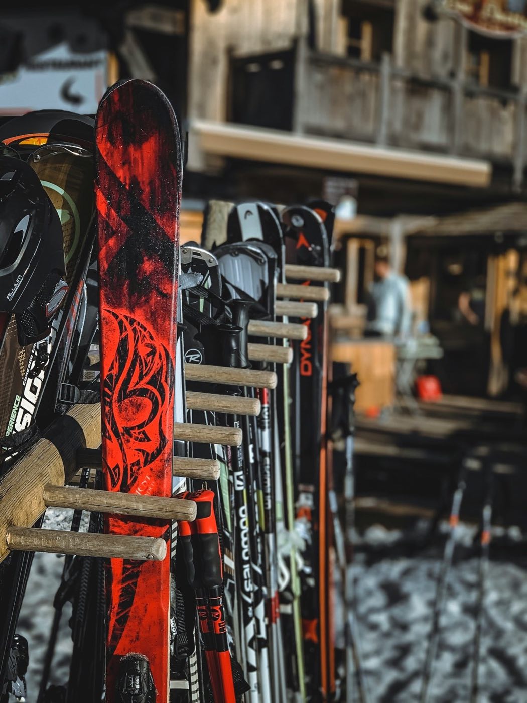 Skis standing in a wooden rack outside a mountain lodge (stock placeholder)